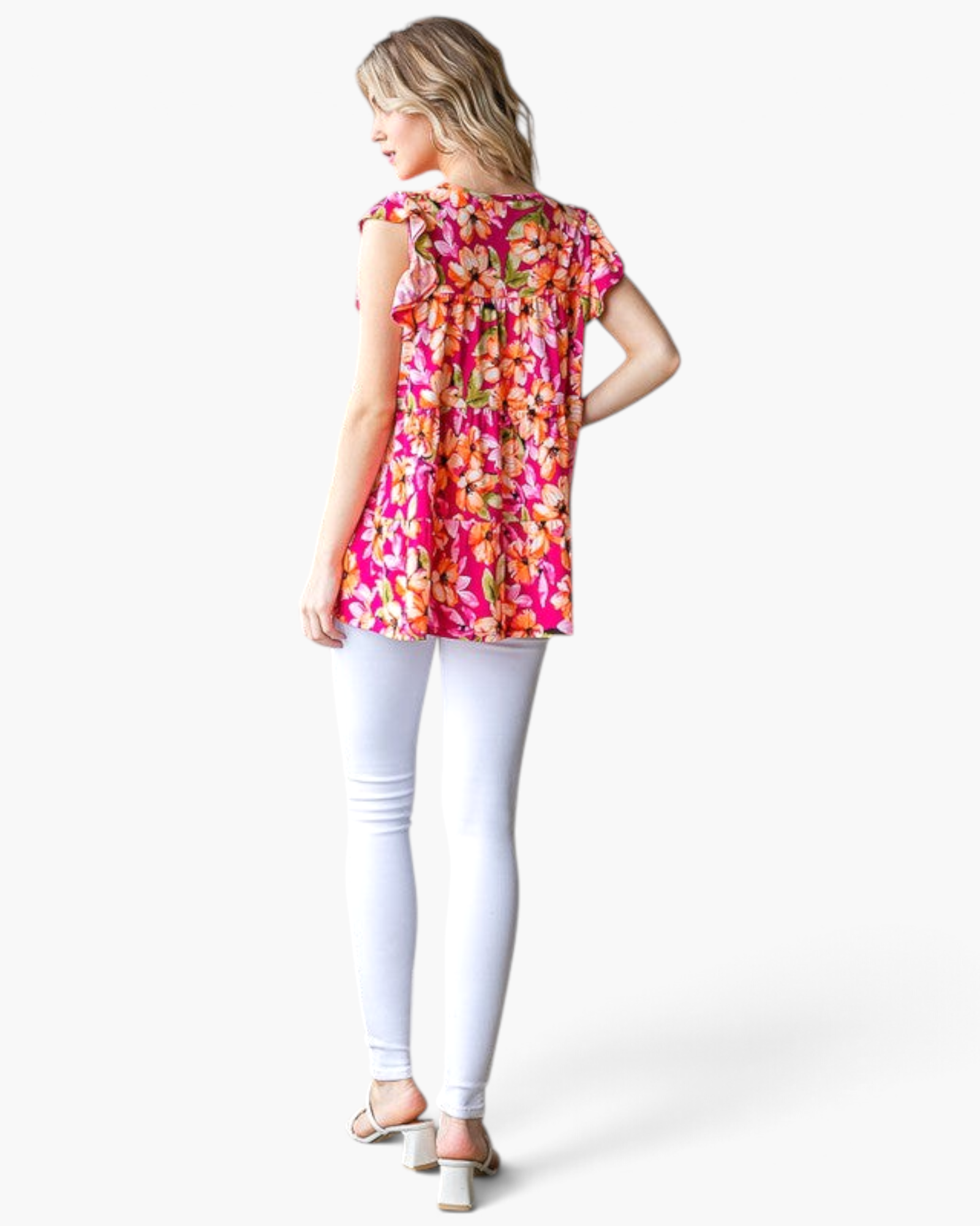 Beach Rose Co. fuchsia floral tiered top with flutter sleeves worn by a model from the back view with white leggings.