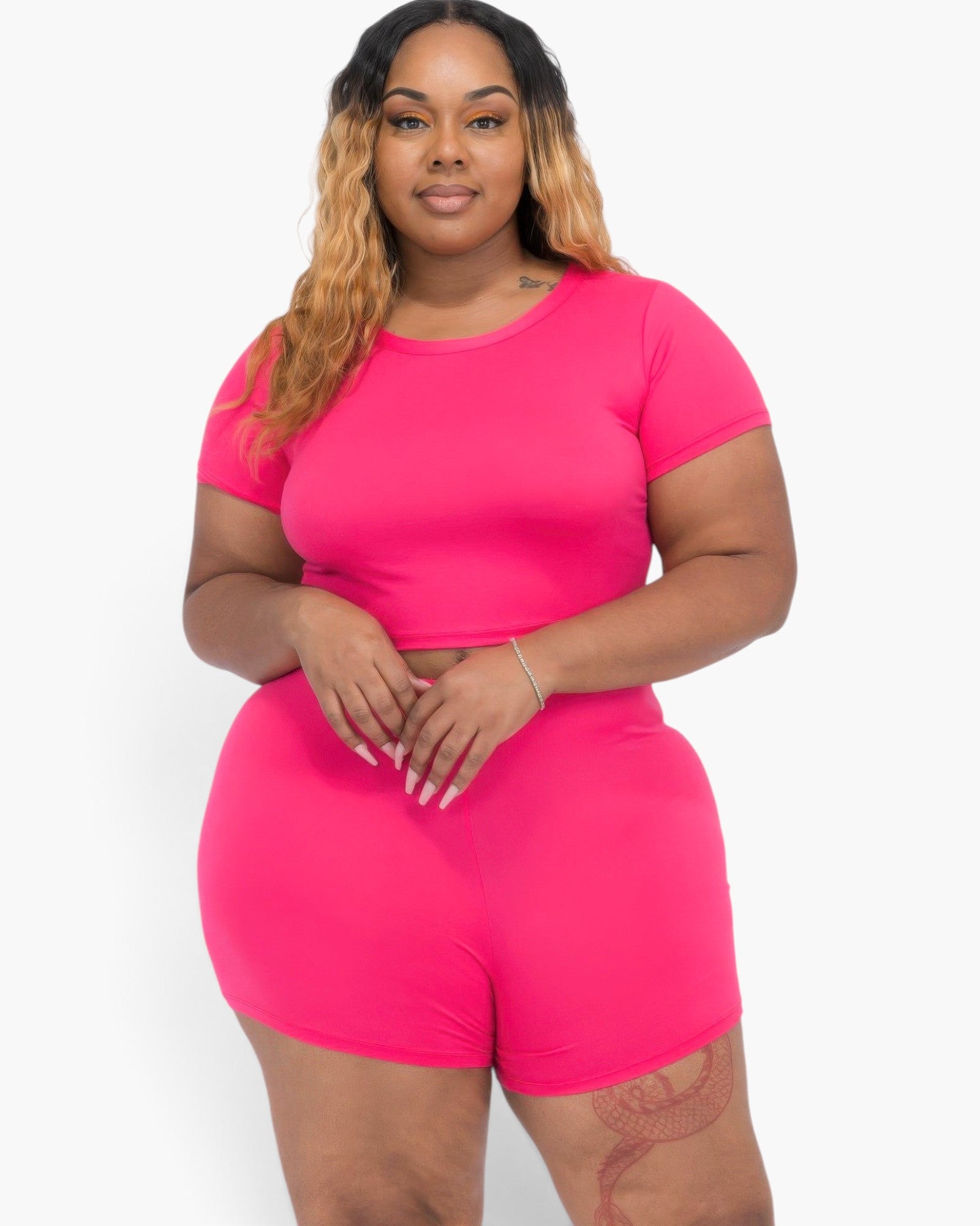 Beach Rose Co. plus size fuchsia short sleeve crop top and shorts set on a model with long blonde-highlighted hair.
