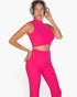 Beach Rose Co. model wearing a vibrant fuchsia ribbed mock neck crop tank top and matching bootcut pants with headphones
