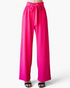 Beach Rose Co. fuchsia wide-leg pants with a textured finish, ruffled elastic waistband, and a front tie detail.