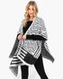 Beach Rose Co. fuzzy chevron pattern ruana in black and white worn by a blonde model over a black long-sleeve top.