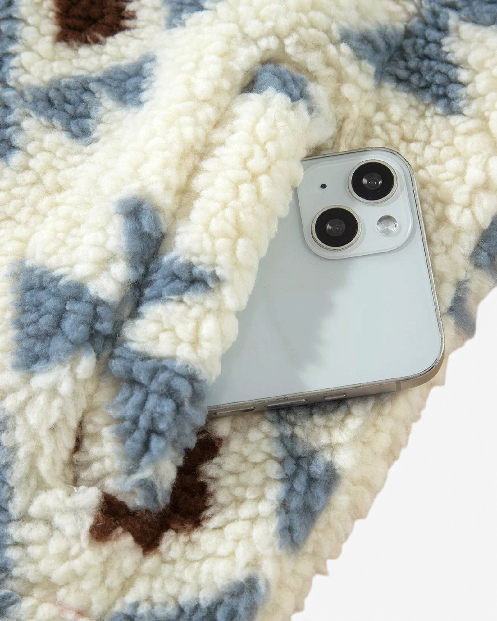 Beach Rose Co. cream sherpa pullover with blue and brown geometric pattern showing a smartphone in the front pocket