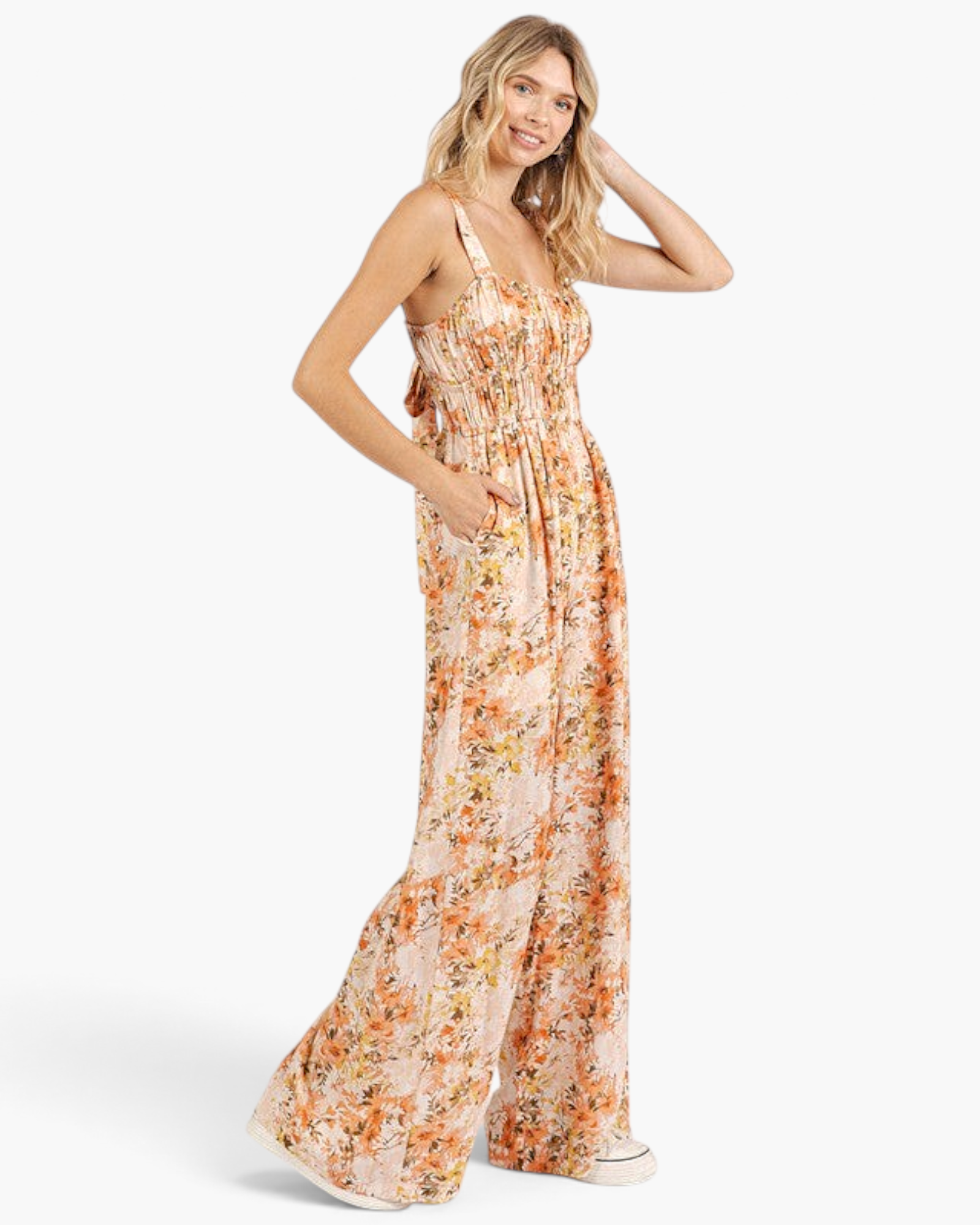 Beach Rose Co. ginger floral wide-leg jumpsuit with a smocked waist, gathered bodice, and side pockets on a model.