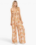 Beach Rose Co. ginger floral wide-leg jumpsuit with a smocked waist, square neckline, and gathered bodice on a model.
