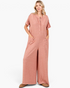 Beach Rose Co. ginger wide-leg jumpsuit with button-front, short sleeves, and patch pockets on a model
