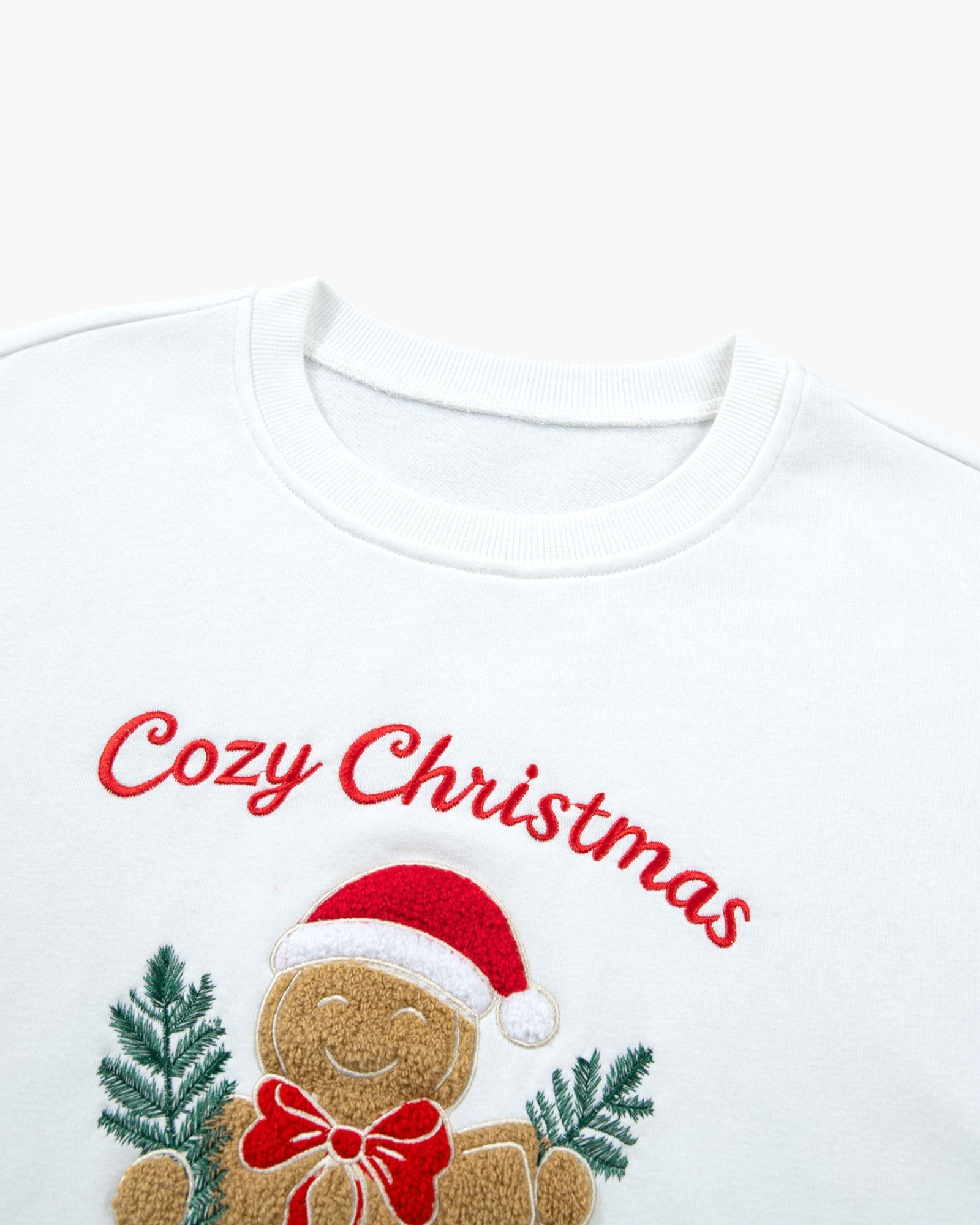 Beach Rose Co. white crew neck sweatshirt featuring a textured gingerbread man appliqué with red Cozy Christmas text.