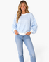 Beach Rose Co. light blue and white gingham sweatshirt with balloon sleeves and white ribbed trim on a smiling model.