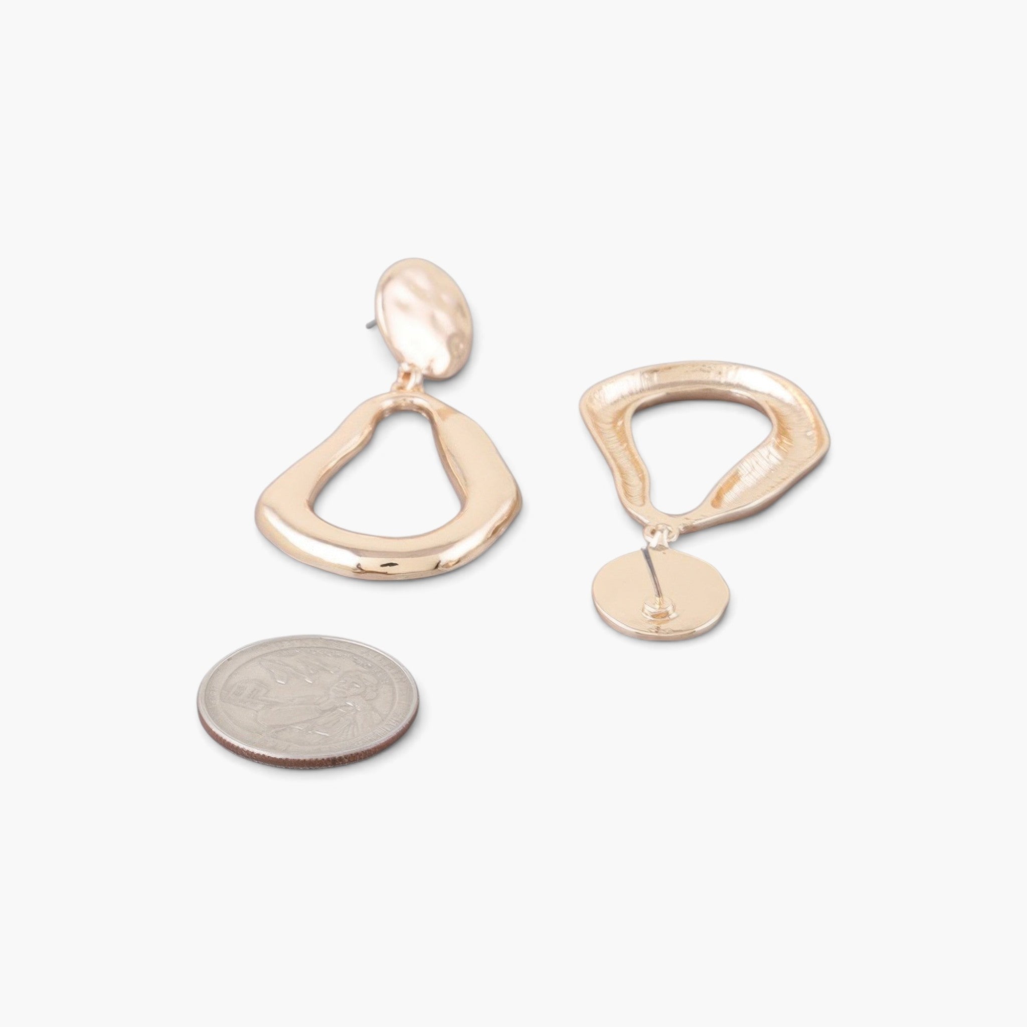 Beach Rose Co. gold-tone abstract teardrop earrings with a polished shiny finish shown next to a US quarter coin.