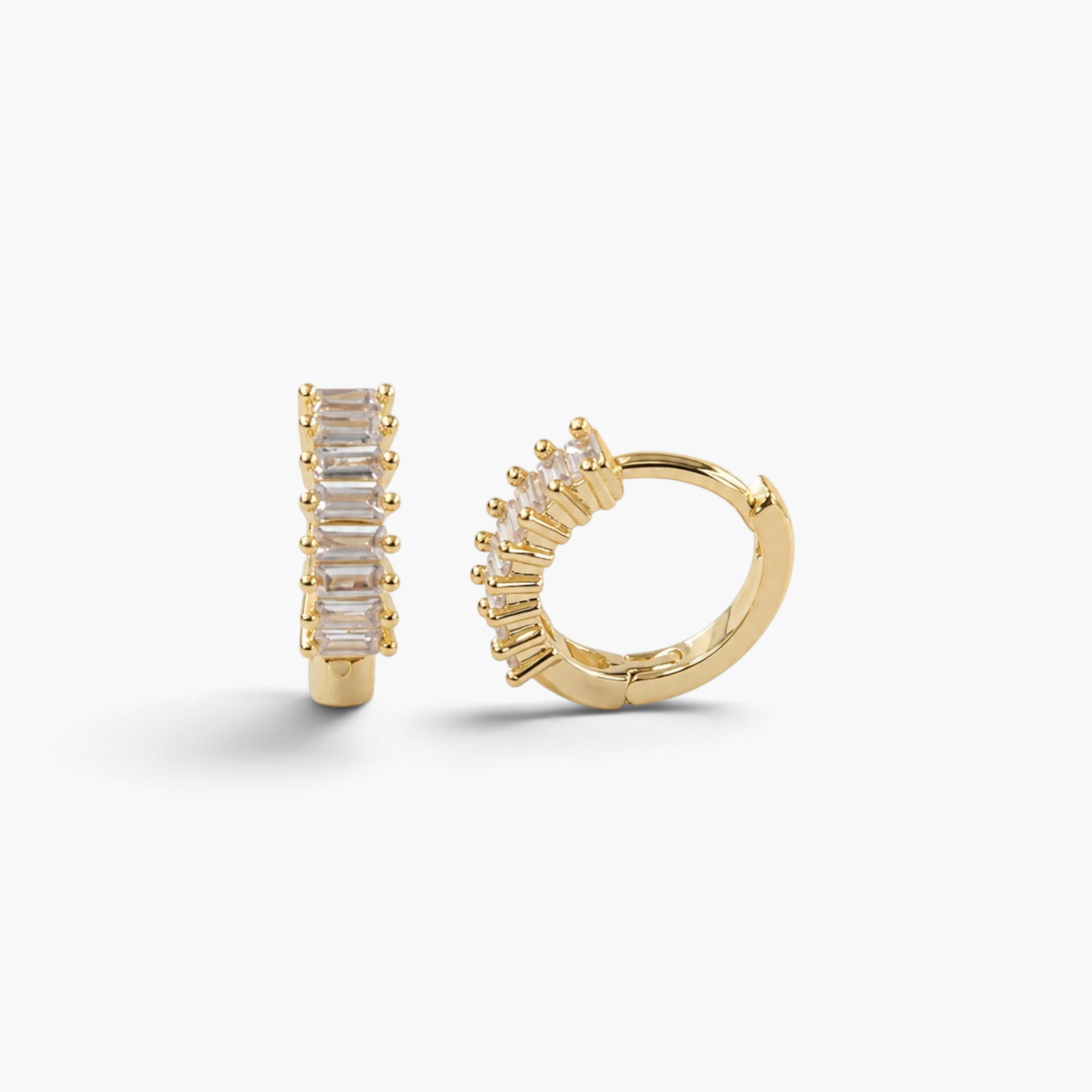 Beach Rose Co. gold huggie hoop earrings featuring a row of sparkling baguette-cut cubic zirconia stones.