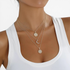 Beach Rose Co. 18K gold-plated layered necklace featuring sunburst, crescent moon, and zircon-accented pendants.