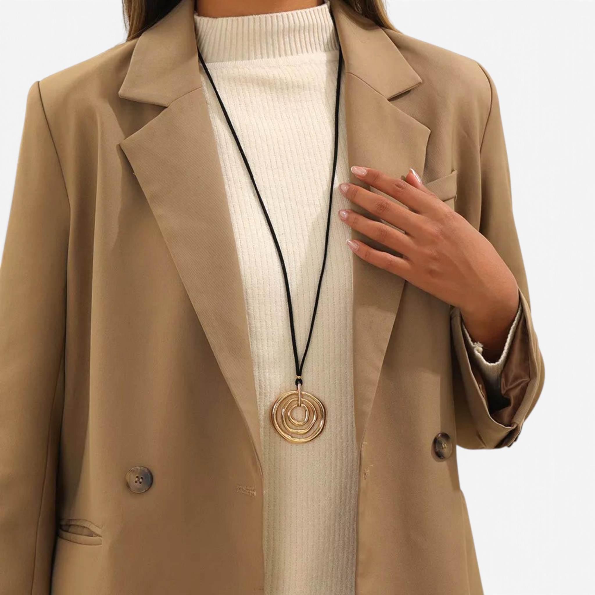 Beach Rose Co. long necklace featuring a gold-plated concentric circle pendant on a black PU cord over a blazer.