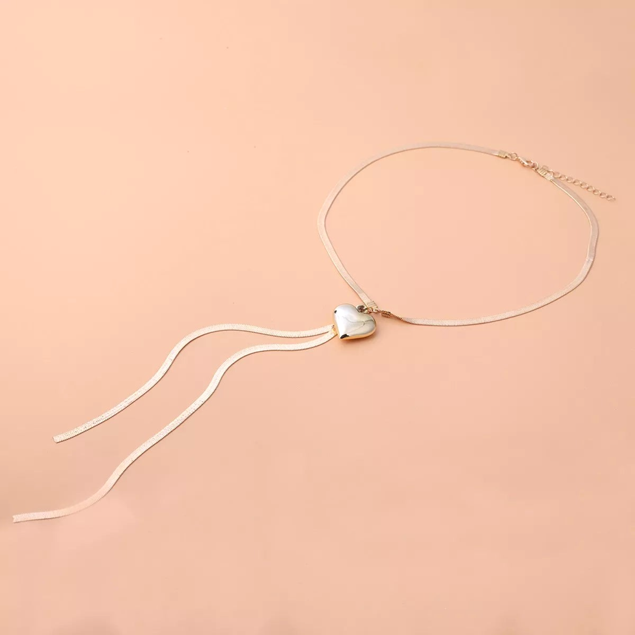 Beach Rose Co. 18K gold-plated necklace featuring a flat herringbone chain, polished heart pendant, and drop chains.