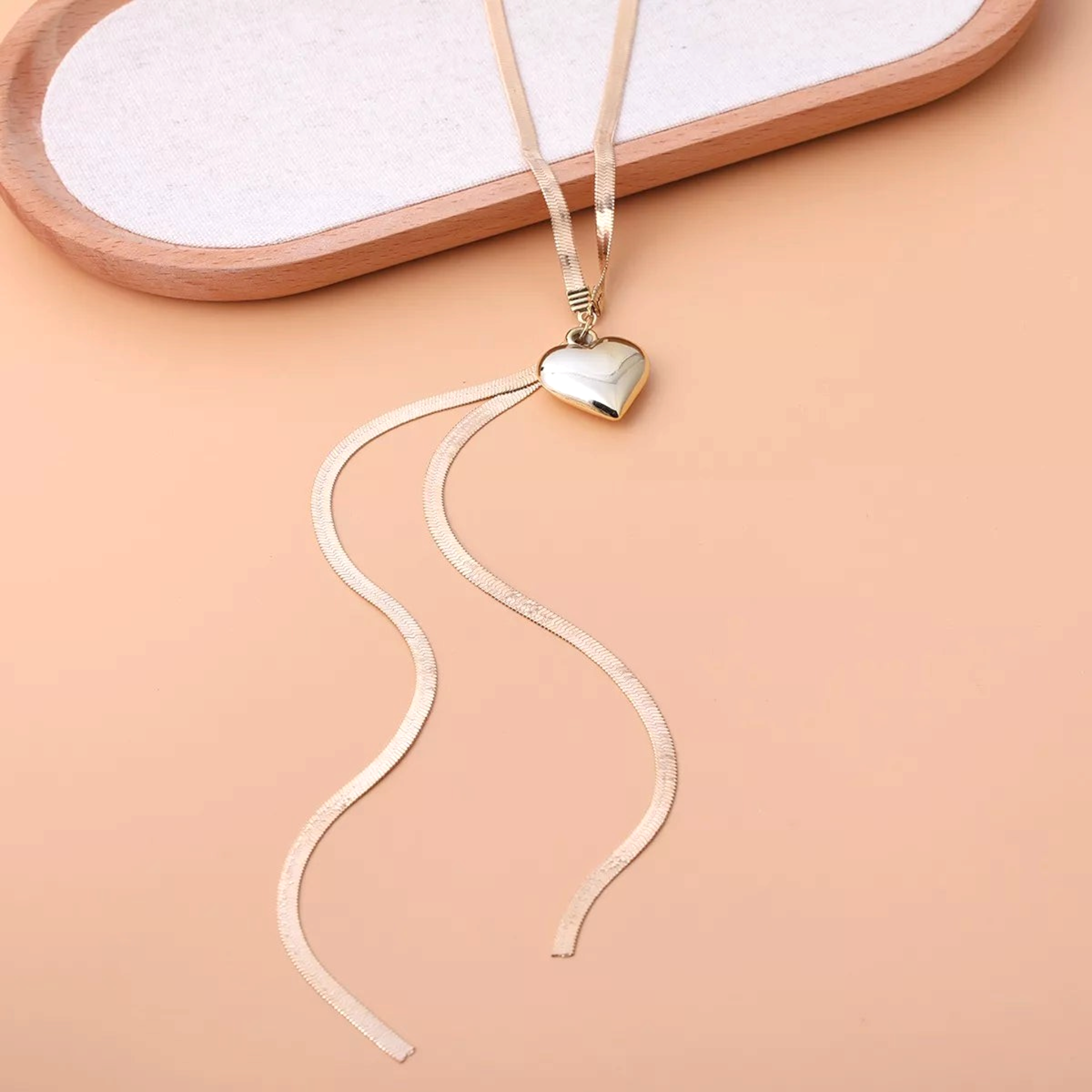 Beach Rose Co. 18K gold-plated necklace featuring a flat herringbone chain, polished heart pendant, and drop chains.