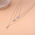 Beach Rose Co. 18K gold-plated layered necklace featuring a zircon sun, teardrop crystal, and crescent moon pendants.