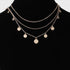 Beach Rose Co. gold layered chain necklace featuring multiple delicate round charms on a black display bust.