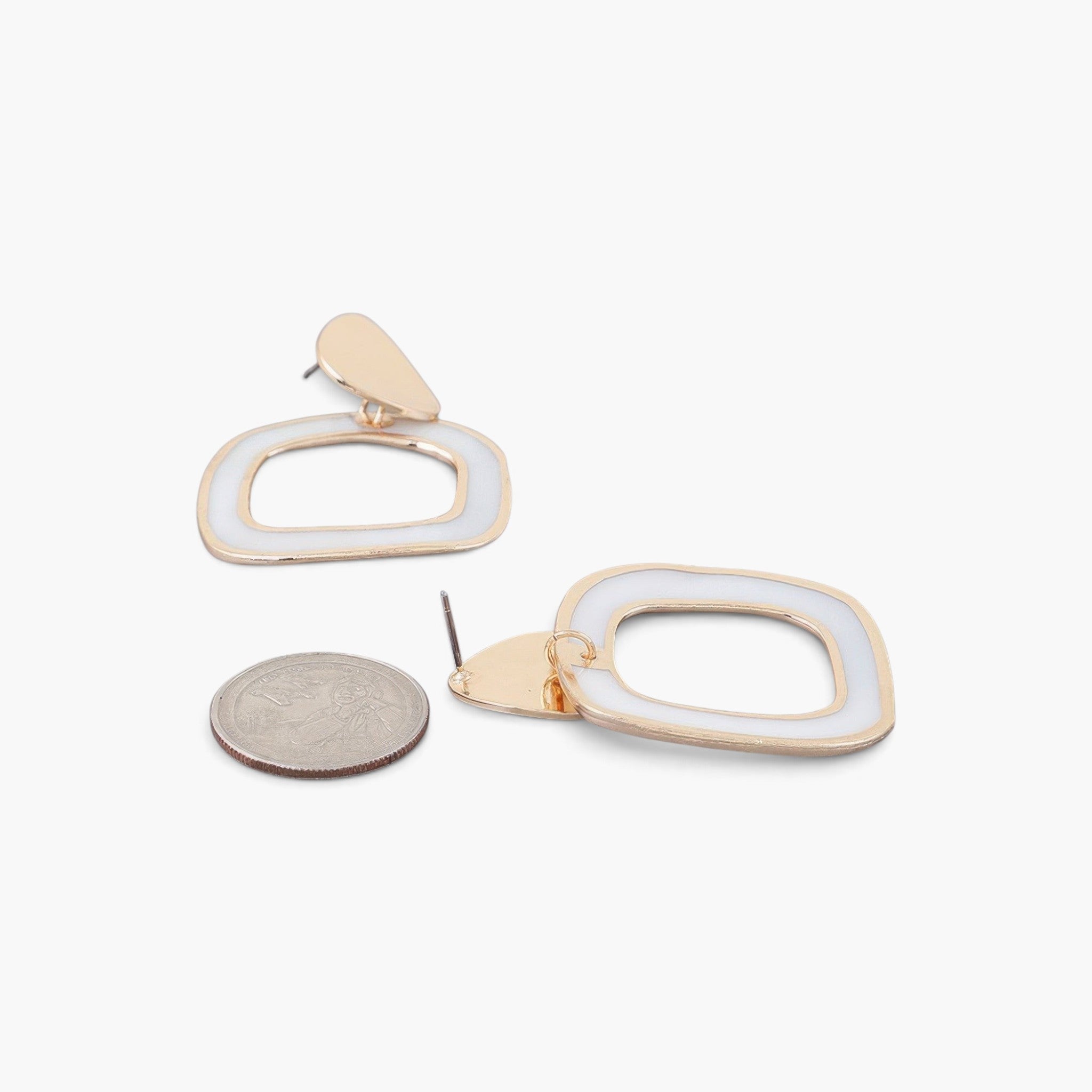 Beach Rose Co. abstract marble frame earrings in gold and cream with a US quarter for scale on a white background.