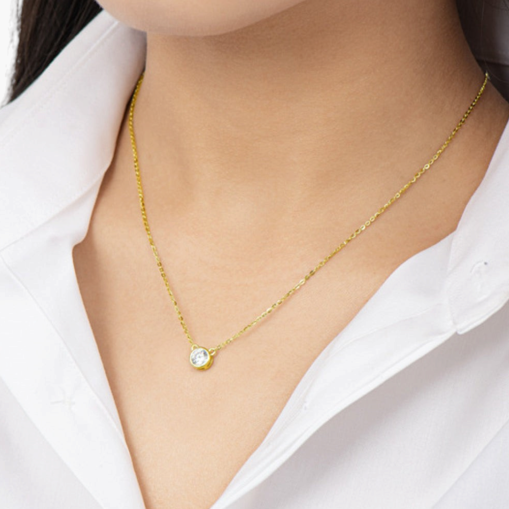 Beach Rose Co. 1 carat round moissanite solitaire necklace in a gold bezel setting on a delicate link chain