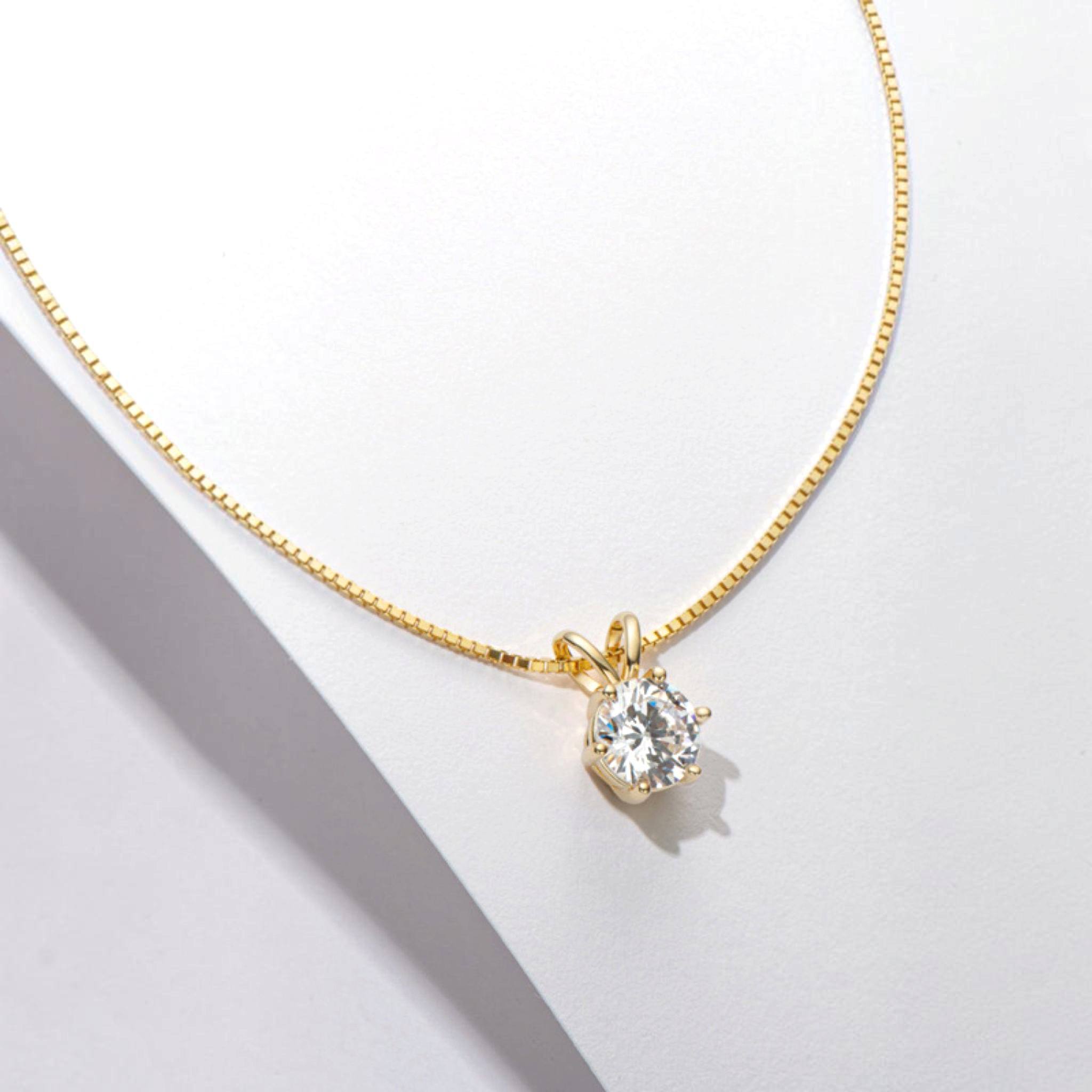 Beach Rose Co. 1 carat round moissanite solitaire pendant necklace on a gold-plated box chain with a V-shaped bail.
