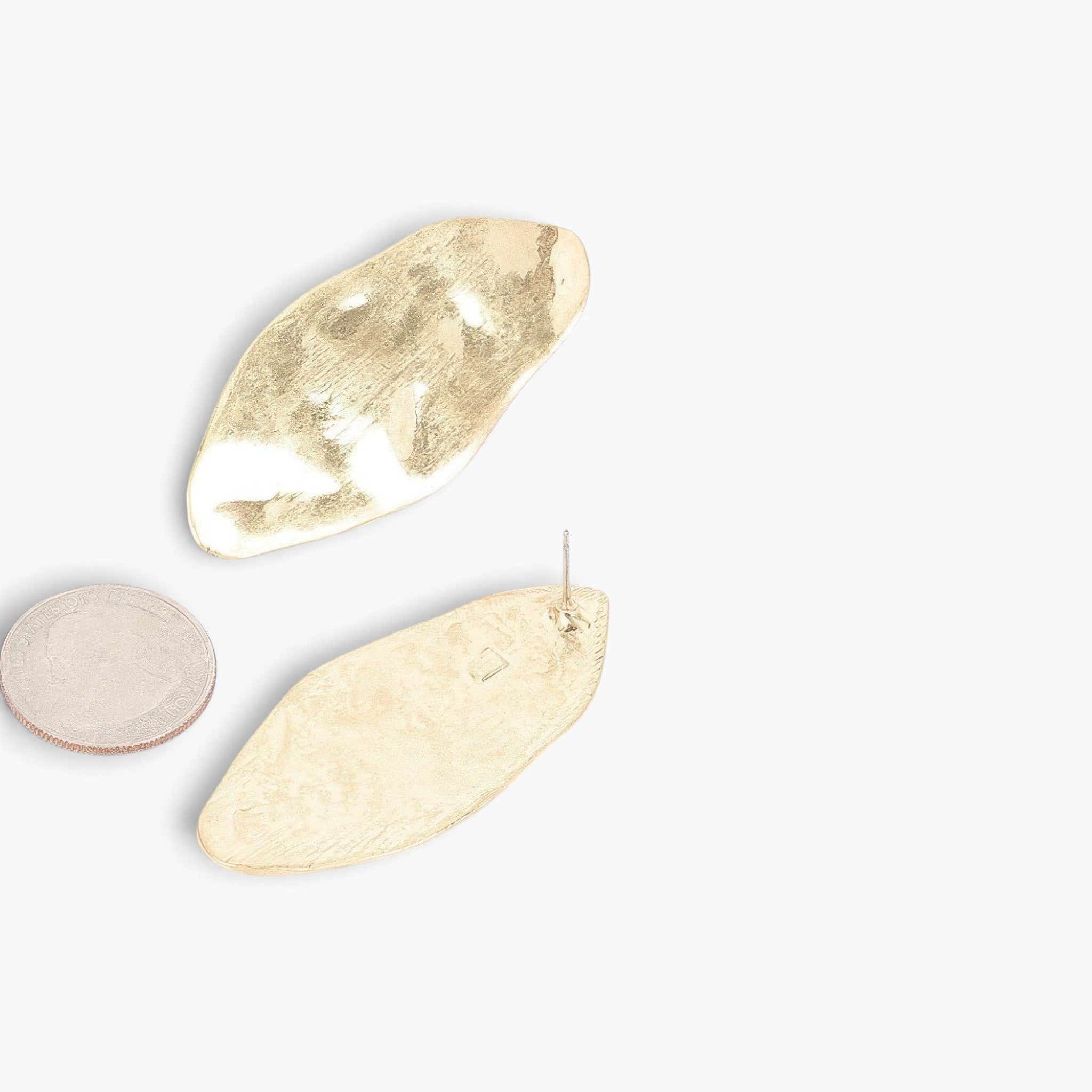 Beach Rose Co. gold-plated metal earrings with a large, textured oval statement design on a white background.