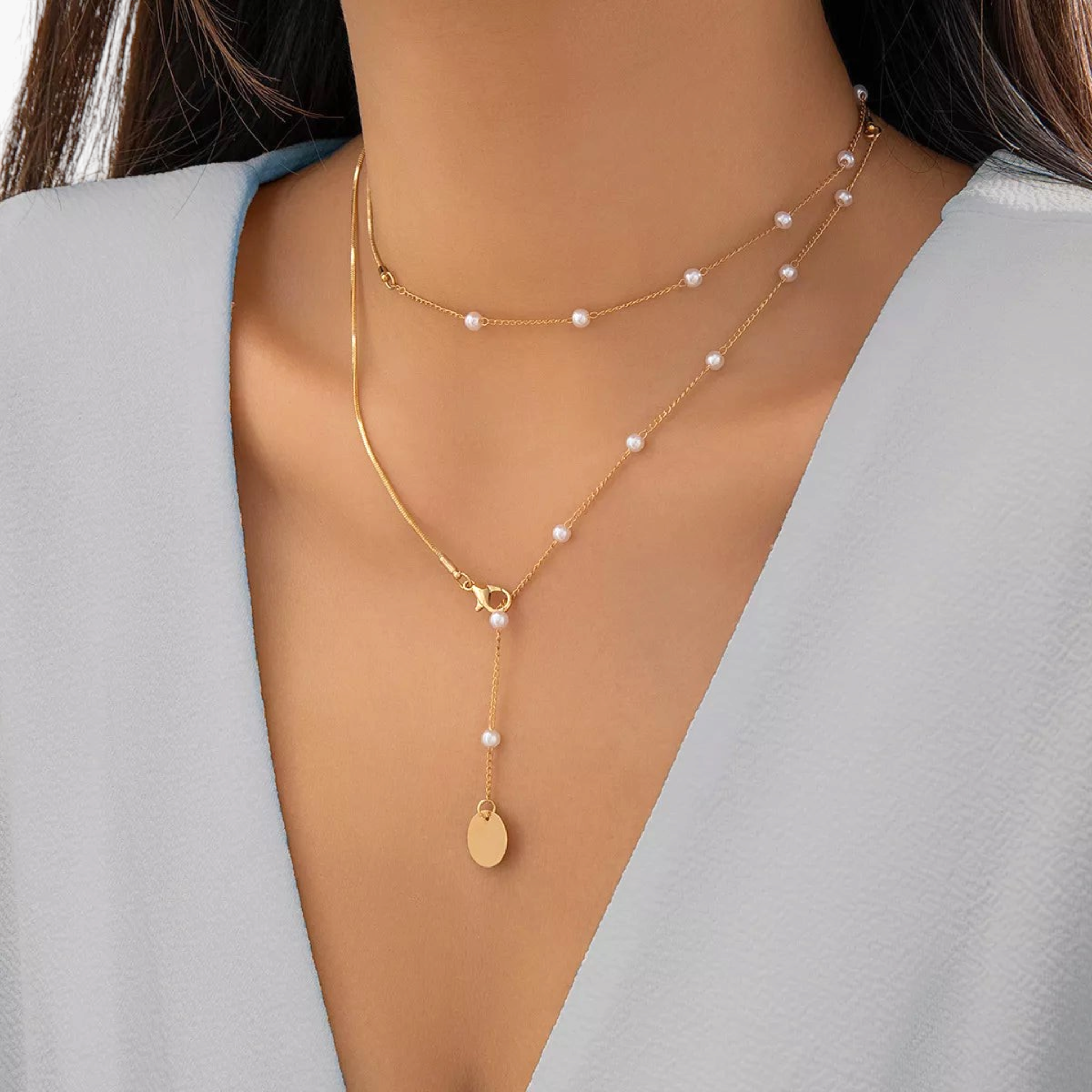 Beach Rose Co. 18K gold-plated lariat necklace featuring white synthetic pearls, mixed chains, and a round disc charm.