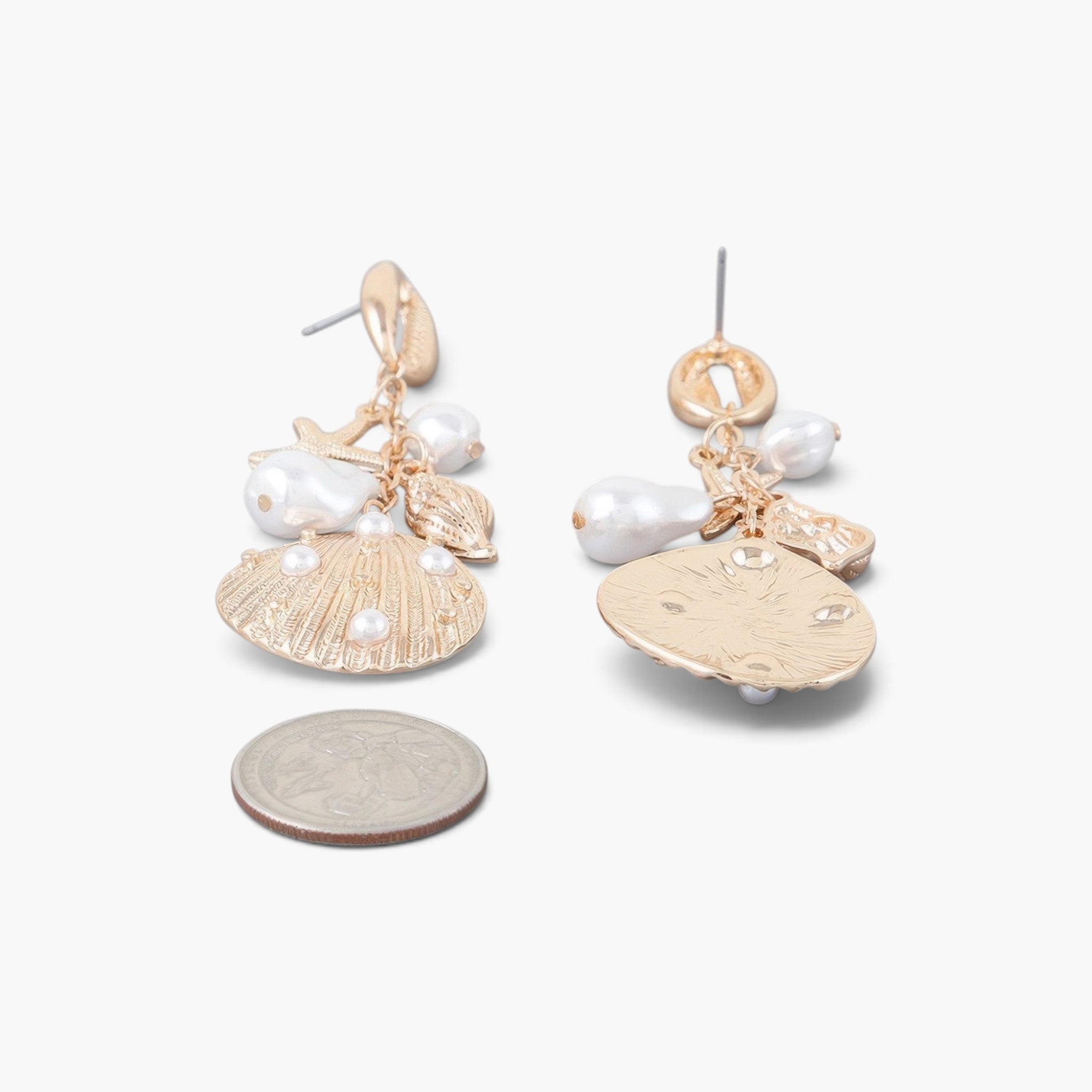 Beach Rose Co. gold-plated drop earrings featuring cream pearls and seashell charms for a coastal elegant style.