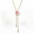Beach Rose Co. 18K gold-plated lariat necklace featuring a pink resin flower and two cascading teardrop chain drops.