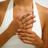 Beach Rose Co. 18K gold-plated five-piece ring set featuring chain-link, stone-accented, and crossover designs.