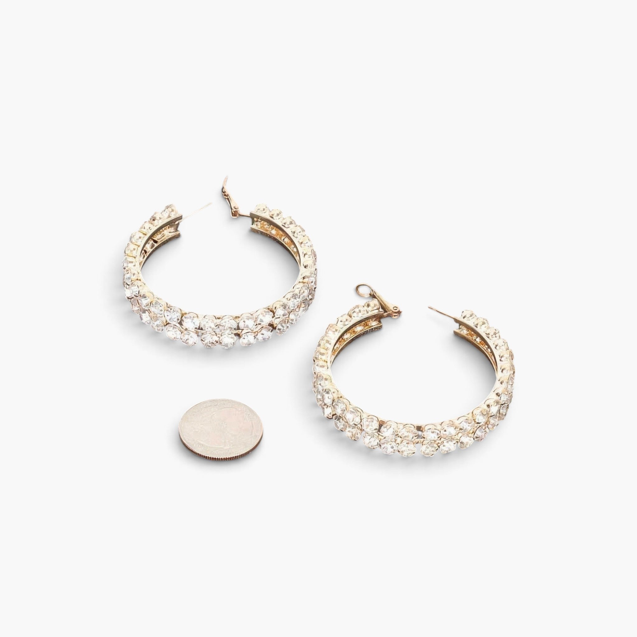 Beach Rose Co. gold double layered hoop earrings featuring sparkling rhinestones next to a coin for size reference.