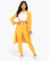 Beach Rose Co. gold ribbed long cardigan and matching leggings set worn by a model with a white crop top.
