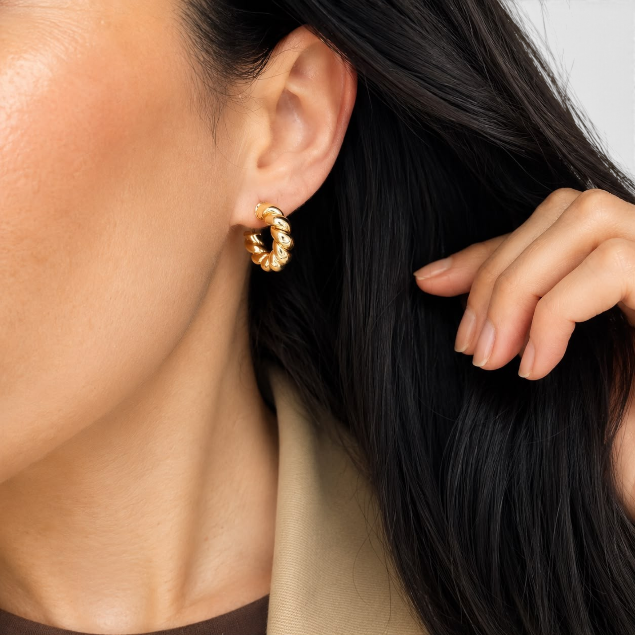 Beach Rose Co. 18K gold filled twisted rope hoop earrings worn on a model with dark hair.
