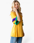 Beach Rose Co. gold top with purple and green color-block layered ruffle sleeves worn by a blonde model.