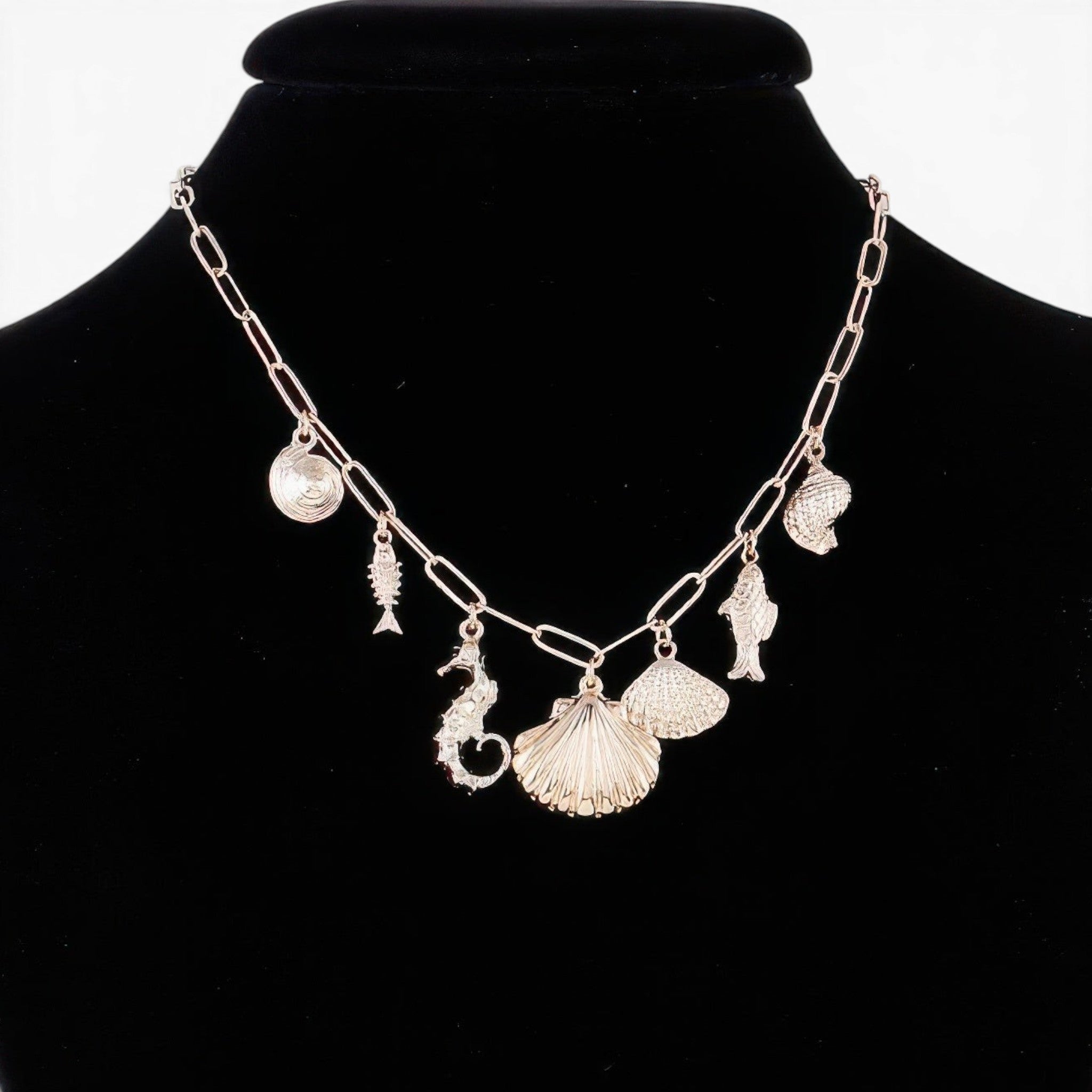 Beach Rose Co. gold chain necklace featuring various ocean-themed charms like a seahorse, seashells, and fish.