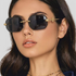 Beach Rose Co. rimless geometric sunglasses with dark lenses and gold snake temple details worn by a woman.