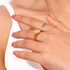 Beach Rose Co. gold-plated signet ring with a starburst engraving and a clear zircon stone on a model's finger.