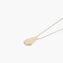 Beach Rose Co. gold teardrop chain necklace with a minimalist disc charm on a delicate chain against a white background