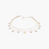 Beach Rose Co. gold triple chain necklace featuring delicate round charms on a polished metal fine chain.