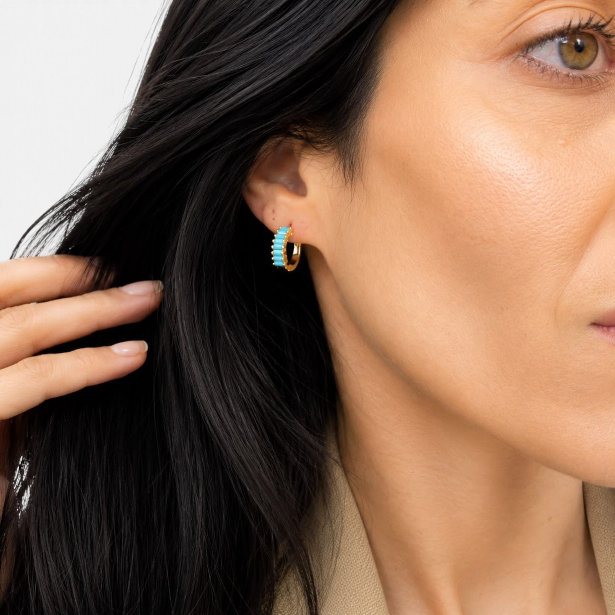 Beach Rose Co. gold huggie earrings featuring a row of vibrant turquoise baguette-cut cubic zirconia stones