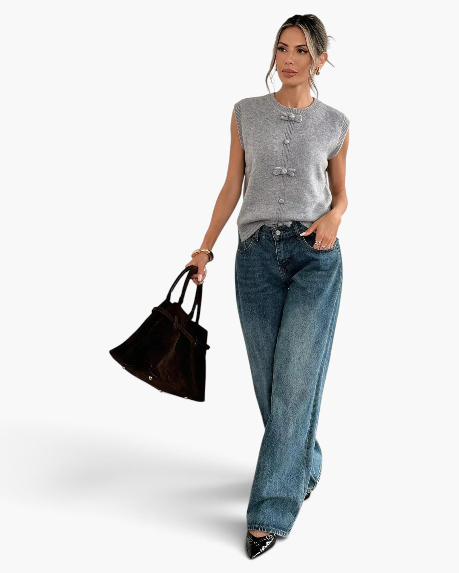 Beach Rose Co. gray sweater vest with decorative bows and buttons, worn by a model with wide-leg jeans and a handbag.