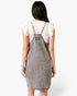 Beach Rose Co. gray washed denim overall dress with racerback straps and contrast stitching worn over a white top
