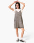Beach Rose Co. gray washed denim overall dress with oversized pockets and slender straps worn over a white top