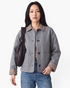 Beach Rose Co. gray button-front jacket with brown and cream gingham collar and cuffs worn by a model with a bag.