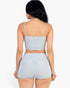Beach Rose Co. gray ribbed cami crop top and ruched shorts set viewed from the back on a model