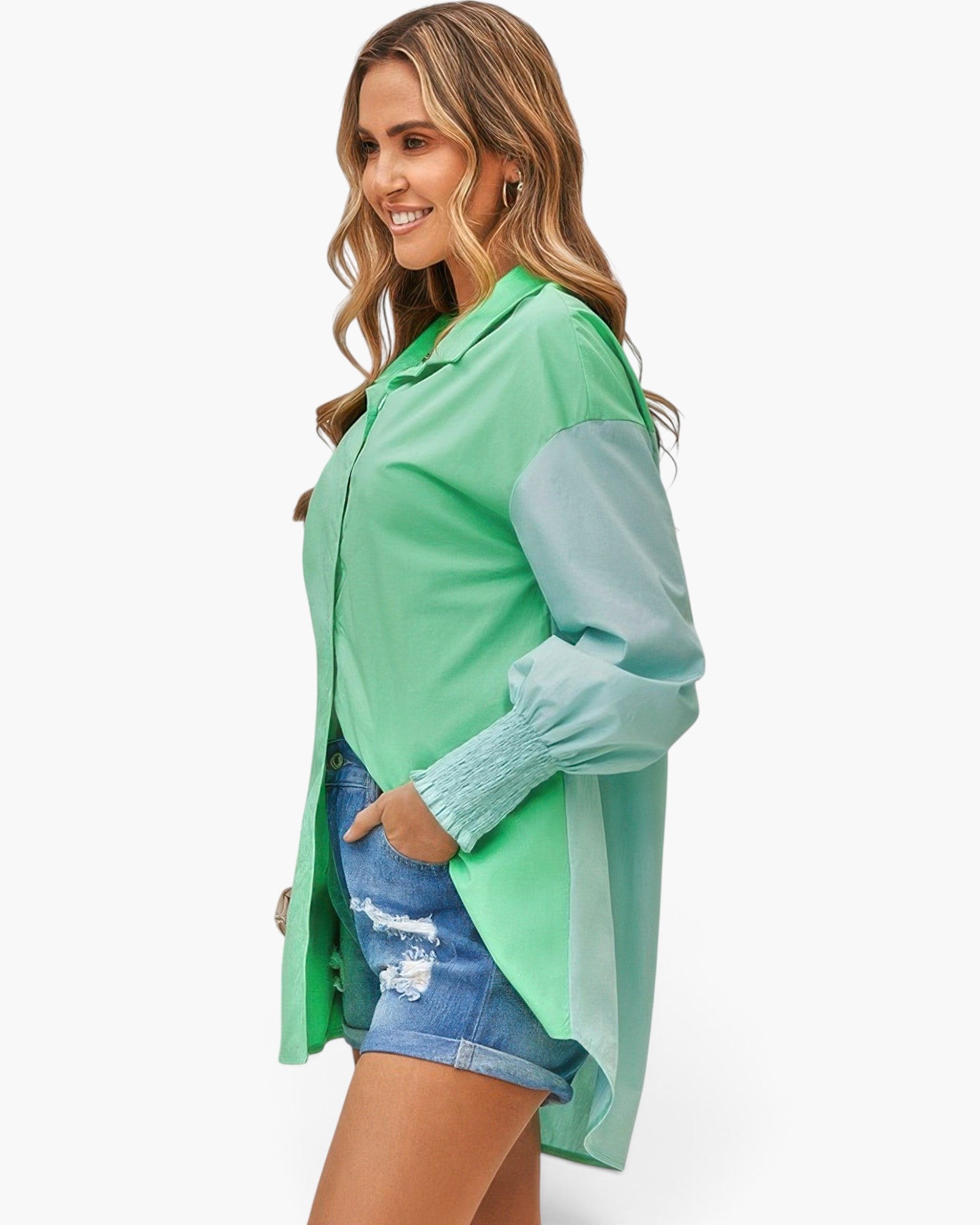 Beach Rose Co. color block button down blouse in green with cuffed sleeves worn by a smiling woman in denim shorts
