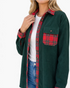Beach Rose Co. forest green corduroy shacket with red plaid collar and pocket details worn over a white tee