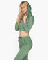 Beach Rose Co. green French terry zip-up cropped hoodie and matching joggers worn by a blonde woman