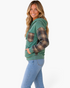 Beach Rose Co. washed green cotton hoodie with brown plaid sleeves and chest pocket worn by a smiling woman