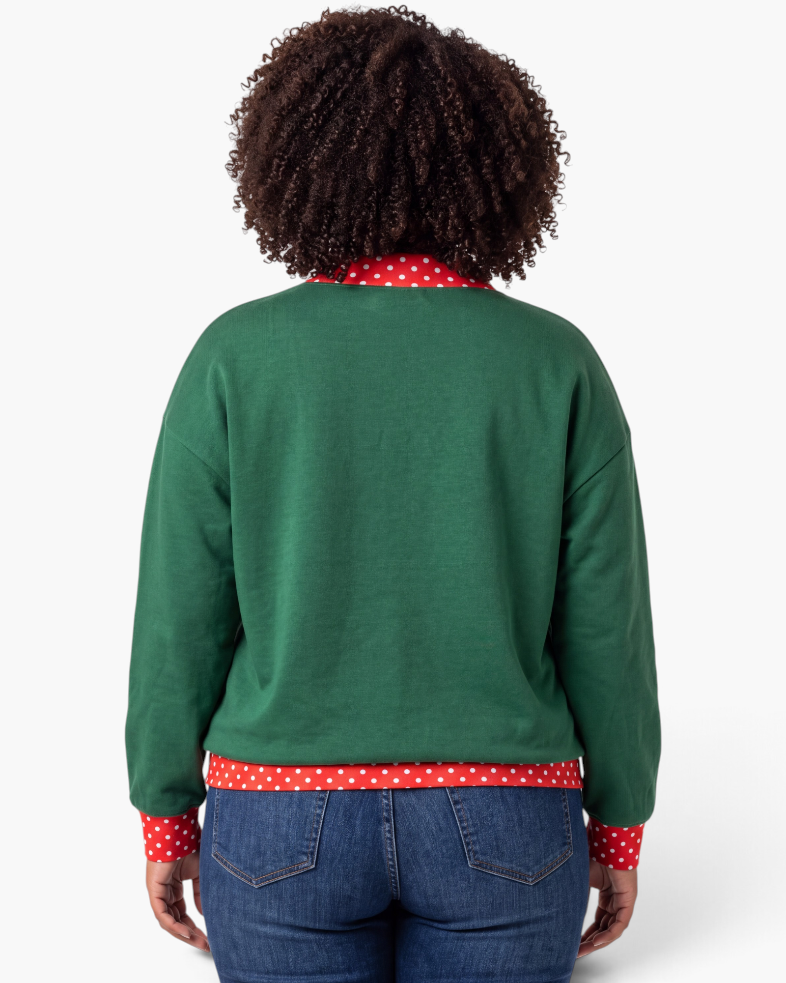 Back view of a model wearing a Beach Rose Co. green sweatshirt with red and white polka dot trim on cuffs and hem.