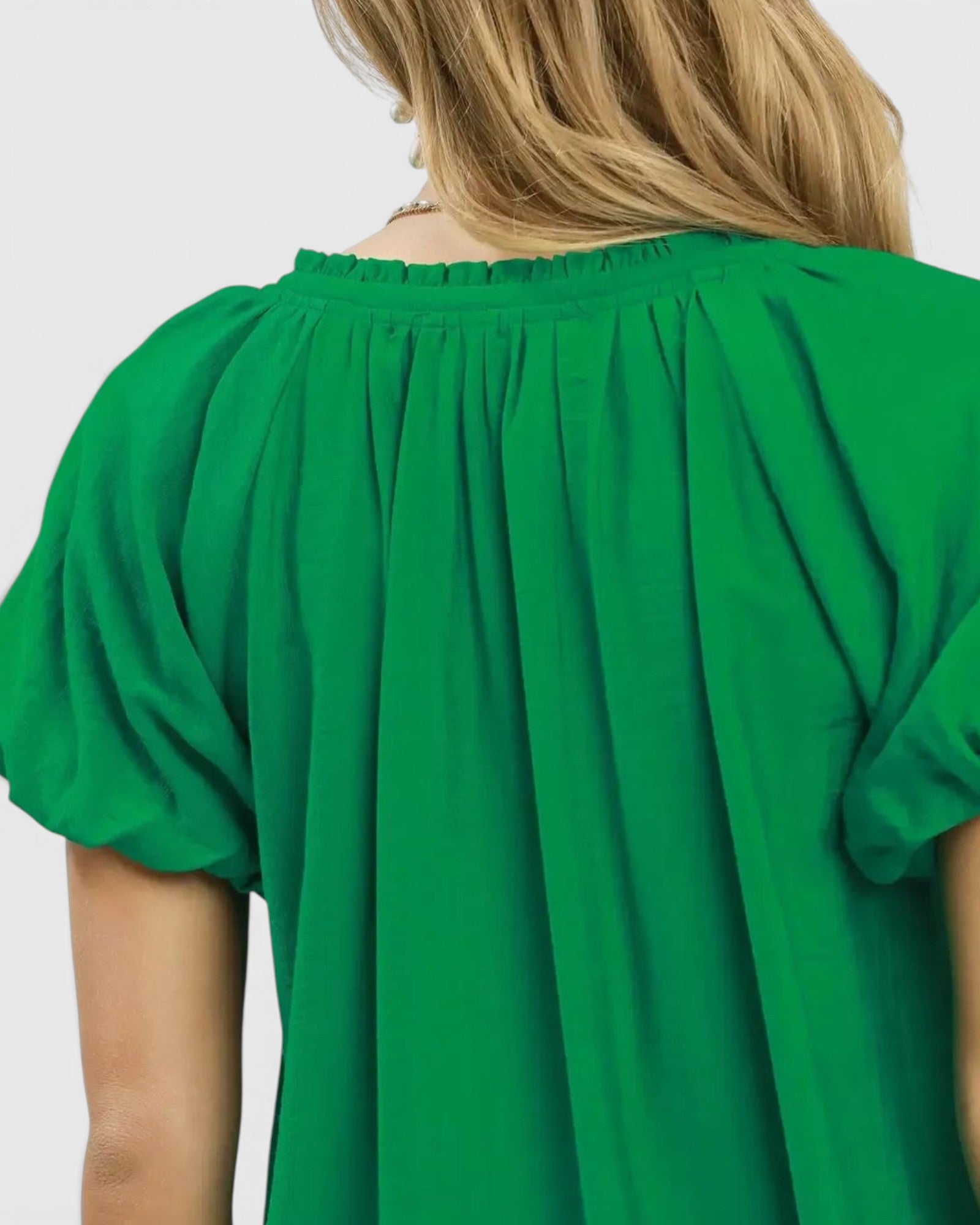 Beach Rose Co. green textured woven blouse with ruffled V-neckline and short puff sleeves.