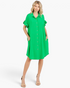 Beach Rose Co. green shirt dress with ruffled sleeves, button front, and side pockets on a model with beige heels.