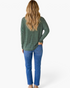 Beach Rose Co. green micro-stripe turtleneck top with dropped shoulders and long sleeves worn with blue jeans